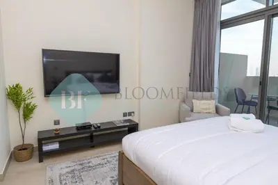 a bedroom with a flat screen tv on the wall at Bloomfields Cozy Stu Azizi Farhad in Dubai