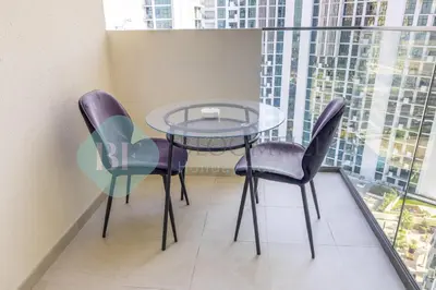 a glass table and chairs in a room with a window at Bloomfields Cozy Stu Azizi Farhad in Dubai