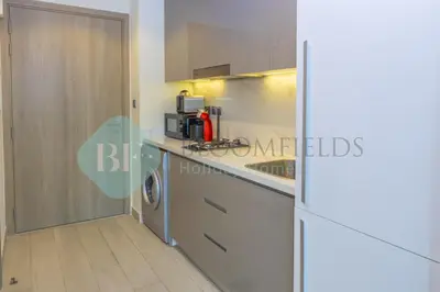 a kitchen with a counter top with a microwave at Bloomfields Cozy Stu Azizi Farhad in Dubai