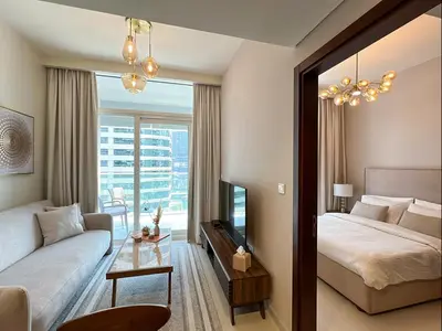 a bedroom with a bed and a couch and a window at Keyrock Living - 1BR at Reva Residence with Lake View in Dubai