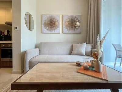 a living room with a couch and a coffee table at Keyrock Living - 1BR at Reva Residence with Lake View in Dubai