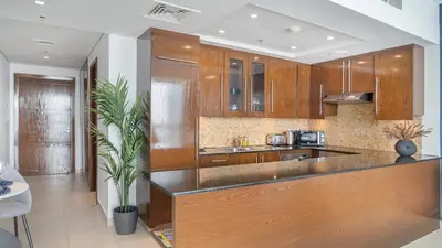 a kitchen with wooden cabinets and a counter top at HAVN - Studio in 8 Boulevard, Downtown Dubai in Dubai
