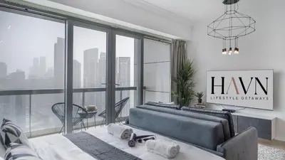 a bedroom with a bed and a large window at HAVN - Studio in 8 Boulevard, Downtown Dubai in Dubai