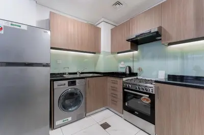 a kitchen with a washing machine and a washer at HAVN - Studio Apartment infront of CircleMall, JVC in Dubai