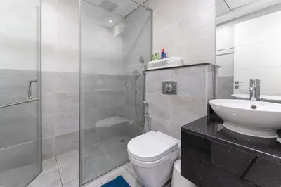 a bathroom with a shower and a toilet and a sink at HAVN - Studio Apartment infront of CircleMall, JVC in Dubai