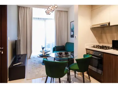 a kitchen and a living room with a table and chairs at Luxury 1-Bedroom Apartment with Pool, Gym & Balcony in Business Bay in Dubai