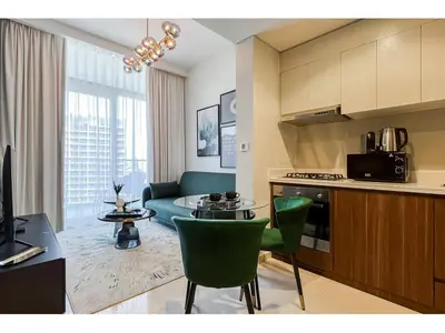 a kitchen and living room with a table and a couch at Luxury 1-Bedroom Apartment with Pool, Gym & Balcony in Business Bay in Dubai