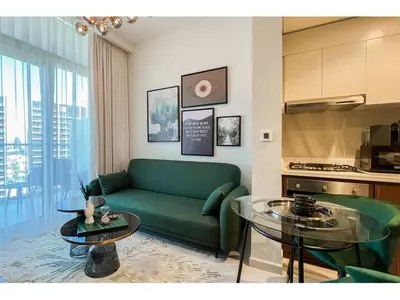 a living room with a green couch and two tables at Luxury 1-Bedroom Apartment with Pool, Gym & Balcony in Business Bay in Dubai