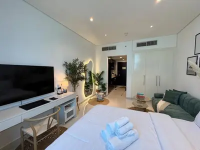 a living room with a large television and a couch at ASHRI HH, Bohemian Style Condo in Downtown in Dubai