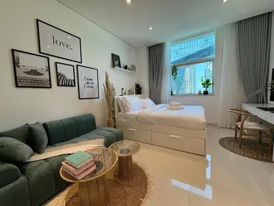 a living room with a couch and a bed at ASHRI HH, Bohemian Style Condo in Downtown in Dubai