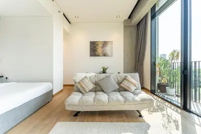 a bedroom with a couch and a large window at HAVN - Studio in KOA Canvas, Access to Nasab Dubai in Dubai