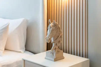 a statue of a horse on a table next to a bed at Stylish JLT Studio Lakeview Metro FrontMarina in Dubai