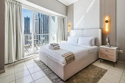 a bedroom with a large bed and a large window at Stylish JLT Studio Lakeview Metro FrontMarina in Dubai