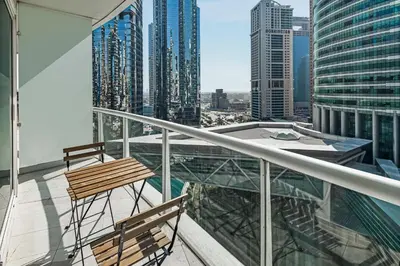 a balcony with two chairs and a view of a city at Stylish JLT Studio Lakeview Metro FrontMarina in Dubai