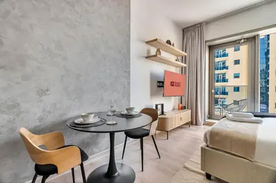 a bedroom with a table and chairs and a bed at GuestReady - Charming studio in Dubai Marina in Dubai