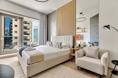 a bedroom with a bed and a chair and a window at GuestReady - Charming studio in Dubai Marina in Dubai