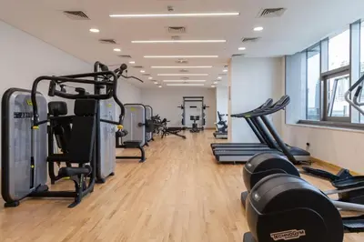 a gym with treadmills and elliptical machines at GuestReady - Charming studio in Dubai Marina in Dubai