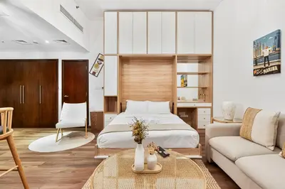 a bedroom with a bed and a couch at Studio APT with Pool, Gym, Squash and Badminton Courts in Dubai