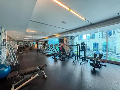 a gym with treadmills and machines in a building at Studio APT with Pool, Gym, Squash and Badminton Courts in Dubai