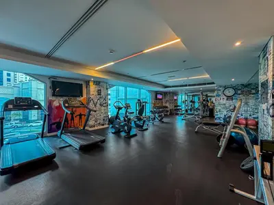 a gym with several treadmills and machines in a room at Studio APT with Pool, Gym, Squash and Badminton Courts in Dubai