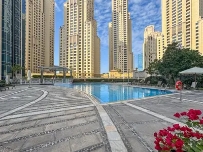 a swimming pool in a city with tall buildings at Studio APT with Pool, Gym, Squash and Badminton Courts in Dubai