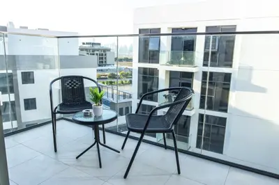 two chairs and a small table on a balcony at Bloomfields Modern 2br Azizi Gardens in Dubai