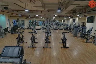 a gym with lots of exercise bikes and treadmills at Calm 1bdr apartment in JVC in Dubai