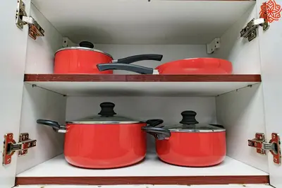 two pots and pans on shelves in a kitchen at Calm 1bdr apartment in JVC in Dubai