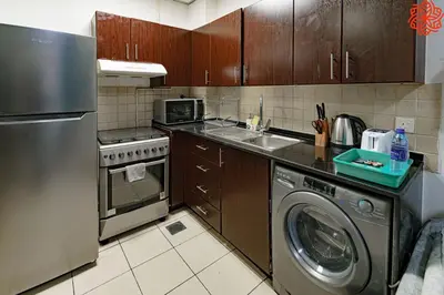 a kitchen with a washing machine and a dishwasher at Calm 1bdr apartment in JVC in Dubai