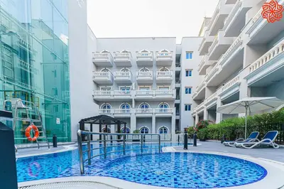 a swimming pool in front of a building at Calm 1bdr apartment in JVC in Dubai