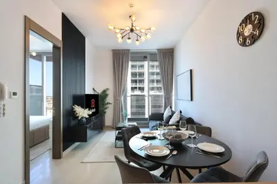 a dining room and living room with a table and chairs at Livbnb-Perfect 1BR Retreat in the Heart of JVC in Dubai