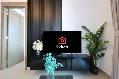 a tv in a living room with a tv in a room at Livbnb-Perfect 1BR Retreat in the Heart of JVC in Dubai