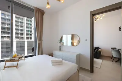 a bedroom with a white bed and a mirror at Livbnb-Perfect 1BR Retreat in the Heart of JVC in Dubai
