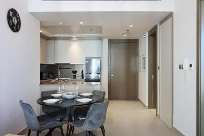 a kitchen and dining room with a table and chairs at Livbnb-Perfect 1BR Retreat in the Heart of JVC in Dubai