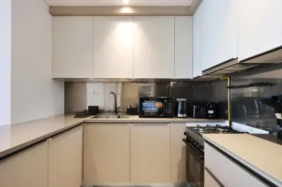 a kitchen with white cabinets and a microwave at Livbnb-Perfect 1BR Retreat in the Heart of JVC in Dubai