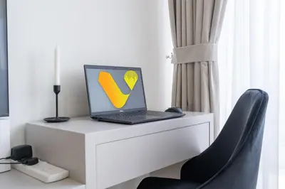 a laptop computer sitting on top of a white desk at Vogue Al Wasl 1 Residences Near Zabeel Park and World Trade Centre, One Bedroom Apartment with Balcony and City View, Access to all Amenities, Walkable to Max Fashion Metro Station in Dubai