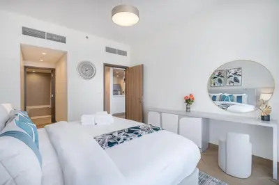 a white room with two beds and a mirror at Vogue Al Wasl 1 Residences Near Zabeel Park and World Trade Centre, One Bedroom Apartment with Balcony and City View, Access to all Amenities, Walkable to Max Fashion Metro Station in Dubai