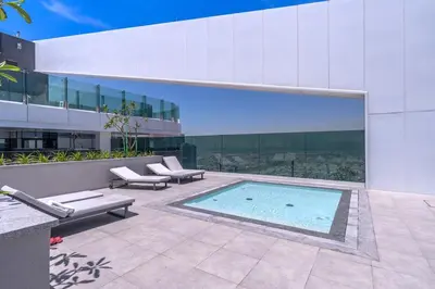 a swimming pool in front of a building at Vogue Al Wasl 1 Residences Near Zabeel Park and World Trade Centre, One Bedroom Apartment with Balcony and City View, Access to all Amenities, Walkable to Max Fashion Metro Station in Dubai