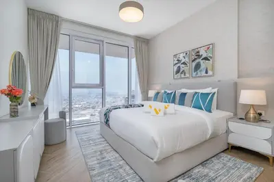 a bedroom with a large bed and a large window at Vogue Al Wasl 1 Residences Near Zabeel Park and World Trade Centre, One Bedroom Apartment with Balcony and City View, Access to all Amenities, Walkable to Max Fashion Metro Station in Dubai