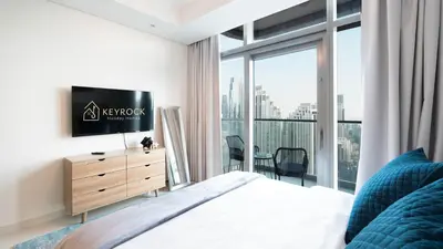 a bedroom with a bed and a tv and a window at 3BR Paramount Downtown - Burj Khalifa View in Dubai