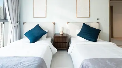 two beds in a room with blue pillows at 3BR Paramount Downtown - Burj Khalifa View in Dubai