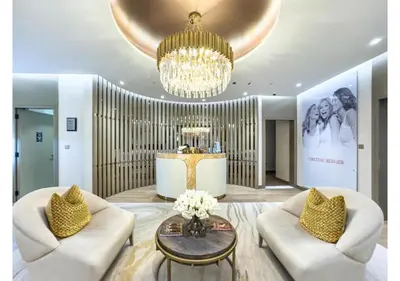 a living room with two white chairs and a chandelier at 3BR Paramount Downtown - Burj Khalifa View in Dubai