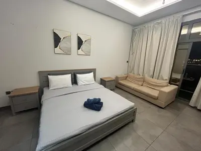 a bedroom with a large bed and a couch at Studio in Business bay, Metro! in Dubai
