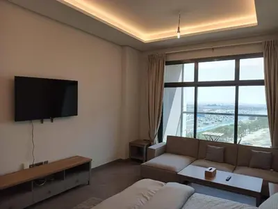 a living room with a couch and a large window at Studio in Business bay, Metro! in Dubai