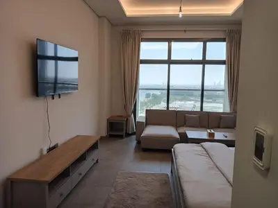 a living room with a couch and a flat screen tv at Studio in Business bay, Metro! in Dubai