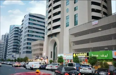 a busy city street with cars parked in front of a building at Contemporary Room in Barsha Heights Tecom Near ICM Metro in Dubai