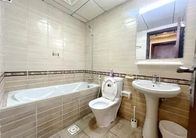 a bathroom with a tub and a toilet and a sink at Contemporary Room in Barsha Heights Tecom Near ICM Metro in Dubai