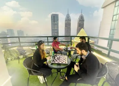 a group of people playing chess on the roof of a building at Contemporary Room in Barsha Heights Tecom Near ICM Metro in Dubai