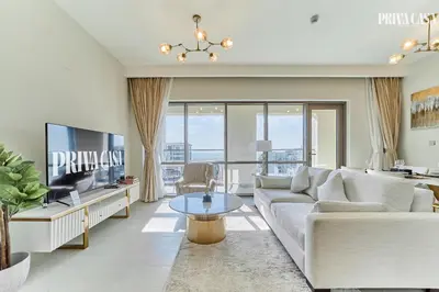 a living room with a white couch and a tv at PRIVA CASA - Luxurious 2BR Vida Creek Beach - Beach access in Dubai