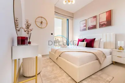 a white bedroom with a large bed with red pillows at City Views 1BR Close to Golf Course & Attractions, Binghatti Venus, Jumeirah Village Circle by Deluxe Holiday Homes in Dubai